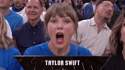 A Woman In A Blue Shirt With The Name Taylor Swift On The Bottom Right GIF
