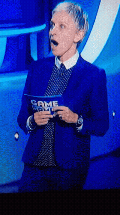 A Woman In A Blue Suit Is Holding A Sign That Says Game Night GIF