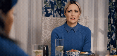 A Woman In A Blue Sweater Sits At A Table With A Plate Of Food GIF