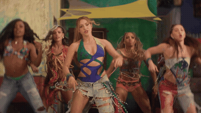 A Woman In A Blue Swimsuit Is Surrounded By Other Women GIF