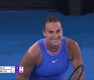 A Woman In A Blue Tank Top Is Holding A Tennis Racquet In Her Hand . GIF