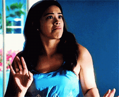 A Woman In A Blue Tank Top Is Making A Face GIF