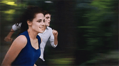 A Woman In A Blue Tank Top Is Running With A Man In A White Shirt GIF