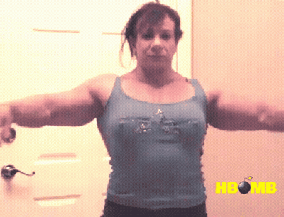 A Woman In A Blue Tank Top Is Standing In Front Of A Door With The Word Hbomb On The Bottom GIF