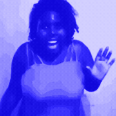 A Woman In A Blue Tank Top Waves Her Hand GIF