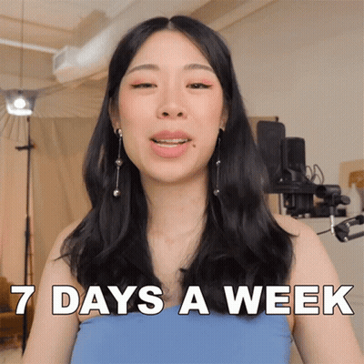 A Woman In A Blue Top Says 7 Days A Week In White Letters GIF