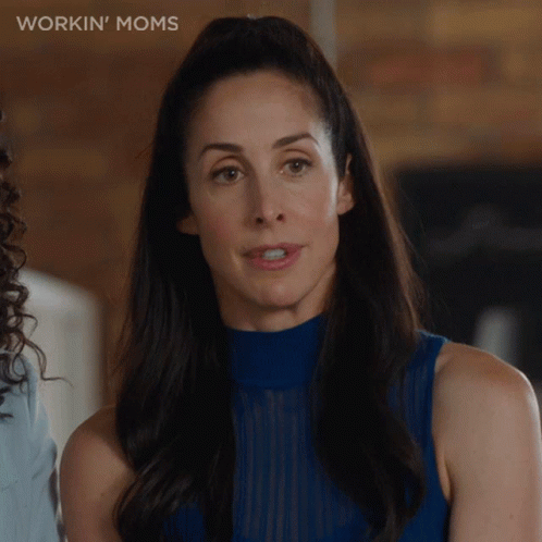 A Woman In A Blue Top With The Words Workin ' Moms Written On The Bottom GIF