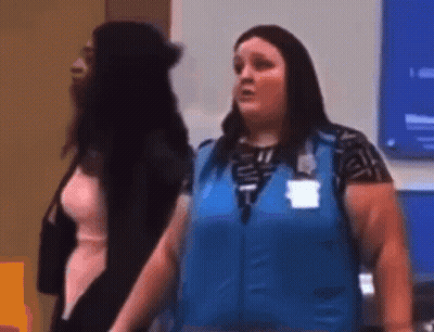 A Woman In A Blue Vest Is Standing Next To Another Woman In A Room . GIF