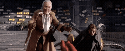 A Woman In A Brown Coat Is Standing Next To A Man GIF
