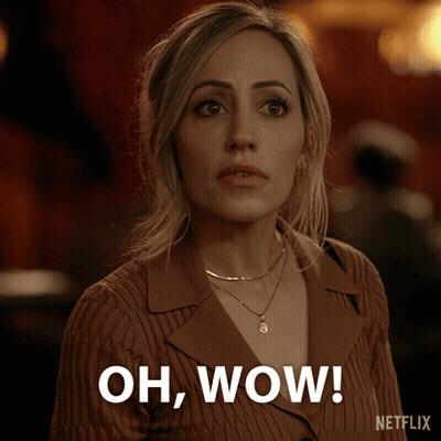 A Woman In A Brown Sweater Is Saying Oh Wow GIF