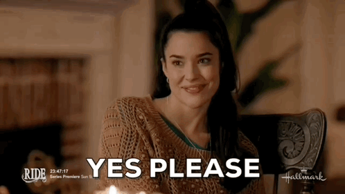 A Woman In A Brown Sweater Is Smiling With The Words Yes Please Behind Her GIF
