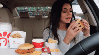 A Woman In A Car Eating A Chicken Sandwich From A Chick-Fil-A Bag GIF