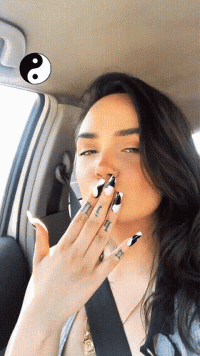 A Woman In A Car Has A Tattoo On Her Finger That Says Ii GIF
