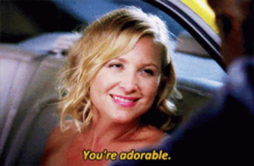 A Woman In A Car Is Smiling And Says You 'Re Adorable In Yellow Letters GIF