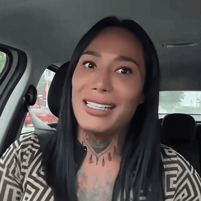 A Woman In A Car With A Tattoo On Her Neck That Says Lyoo GIF