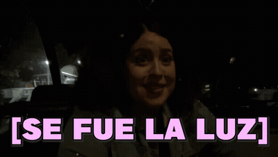 A Woman In A Car With The Words Se Fue La Luz Written In Pink GIF