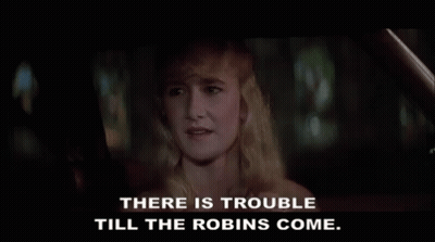 A Woman In A Car With The Words " There Is Trouble Till The Robins Come " Below Her GIF