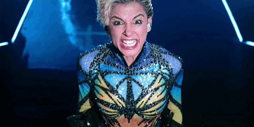 A Woman In A Colorful Costume Making A Funny Face GIF