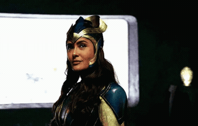 A Woman In A Costume Is Standing In Front Of A Window And Looking At The Camera . GIF