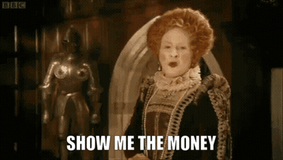 A Woman In A Costume Says Show Me The Money In Front Of A Statue GIF