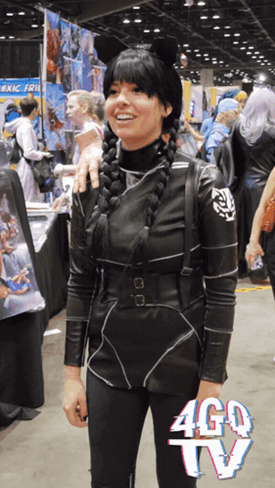 A Woman In A Costume Stands In Front Of A Sign That Says Ago Tv GIF