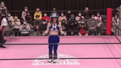 A Woman In A Cowboy Hat Is Standing In A Wrestling Ring In Front Of A Crowd GIF