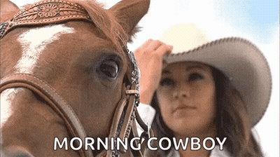 A Woman In A Cowboy Hat Is Standing Next To A Horse With The Words Morning Cowboy Written On The Bottom GIF