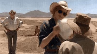 A Woman In A Cowboy Hat Is Talking To A Man In A Cowboy Hat . GIF