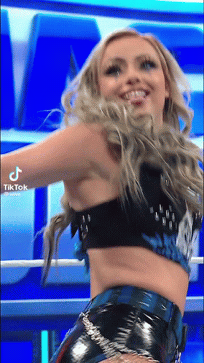 A Woman In A Crop Top And Shorts Is Dancing In A Ring . GIF