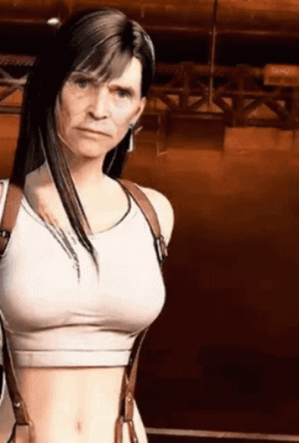 A Woman In A Crop Top And Suspenders Is Standing In Front Of A Brown Wall . GIF