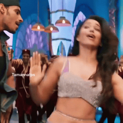 A Woman In A Crop Top Is Dancing With A Man In A Hat . GIF