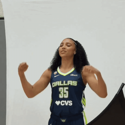 A Woman In A Dallas 35 Cvs Jersey Flexes Her Arms GIF