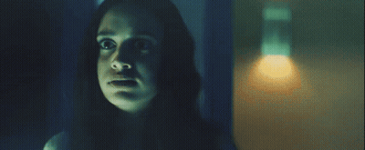 A Woman In A Dark Room With A Light On GIF