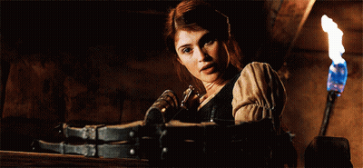 A Woman In A Dark Room With A Torch And A Bottle In Her Hand GIF