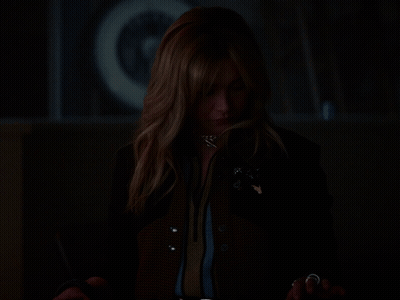A Woman In A Dark Room With Her Hands Out GIF