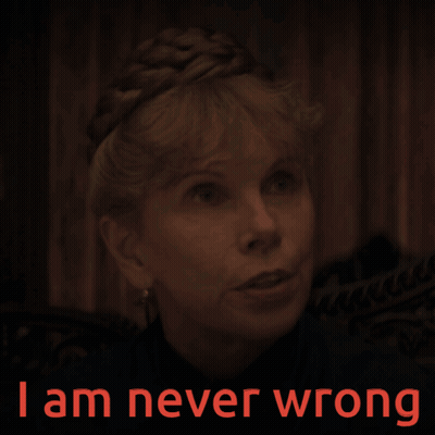 A Woman In A Dark Room With The Words " I Am Never Wrong " On The Bottom GIF