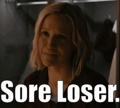 A Woman In A Dark Room With The Words Sore Loser On The Bottom GIF