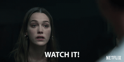 A Woman In A Dark Room With The Words Watch It Written Below Her GIF