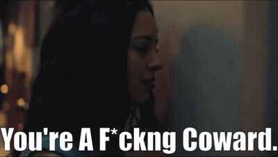 A Woman In A Dark Room With The Words You 'Re A F * Cking Coward GIF