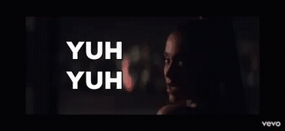 A Woman In A Dark Room With The Words Yuh Yuh On The Bottom GIF