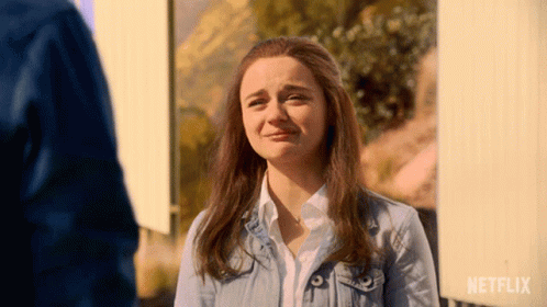 A Woman In A Denim Jacket Is Crying In Front Of A Sign That Says Netflix GIF