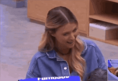 A Woman In A Denim Jacket Is Holding A Baby In A Crib . GIF