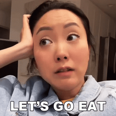 A Woman In A Denim Jacket Says Let 'S Go Eat With Her Hand On Her Head GIF