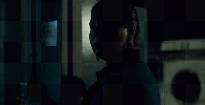 A Woman In A Denim Jacket Stands In Front Of A Fire Extinguisher GIF