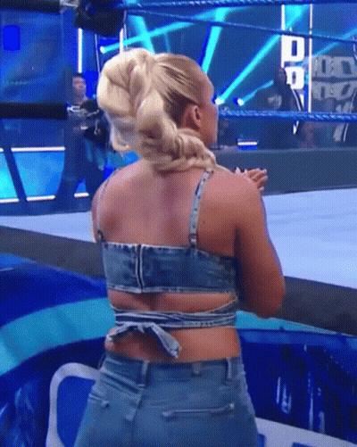 A Woman In A Denim Top Is Standing In A Wrestling Ring GIF