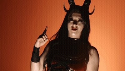 A Woman In A Devil Costume With Horns Pointing Up GIF