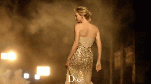A Woman In A Dior Dress Walking Down A Street GIF