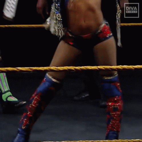 A Woman In A Diva Outfit Is Standing In A Roped In Area GIF