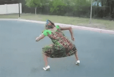 A Woman In A Dress Is Dancing On A Skateboard On The Street . GIF