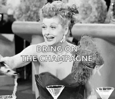 A Woman In A Dress Is Sitting At A Table With Two Martini Glasses And A Glass Of Champagne . GIF